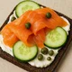 Pikantes Pumpernickel mit Räucherlachs, Gurke und Kapern – Bild 1