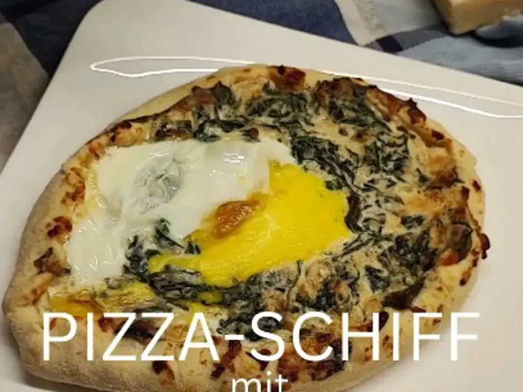 Pizza-Schiff mit Spinat und Spiegelei